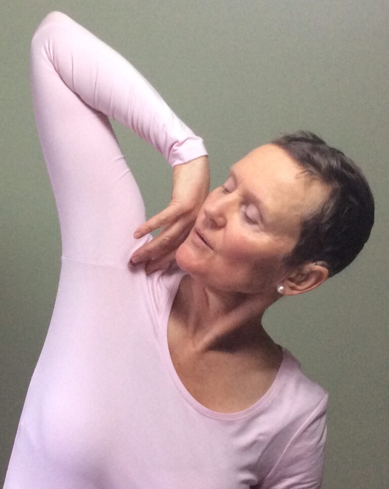 Pippa demonstrating somatic therapy movement easing out contraction in the shoulders and chest.